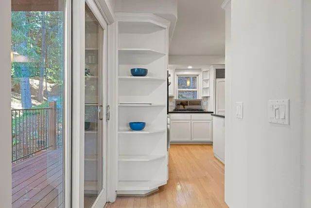 a kitchen with stainless steel appliances kitchen island granite countertop a refrigerator oven a sink a dining table and chairs with wooden floor