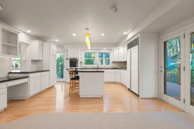 a kitchen with granite countertop white cabinets and white appliances