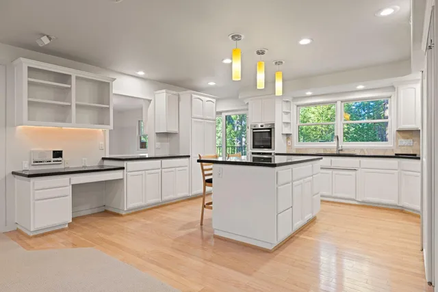 a kitchen with stainless steel appliances kitchen island granite countertop a table and chairs in it