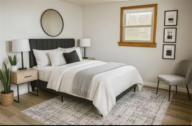 a bedroom with a bed a mirror and a lamp on dresser