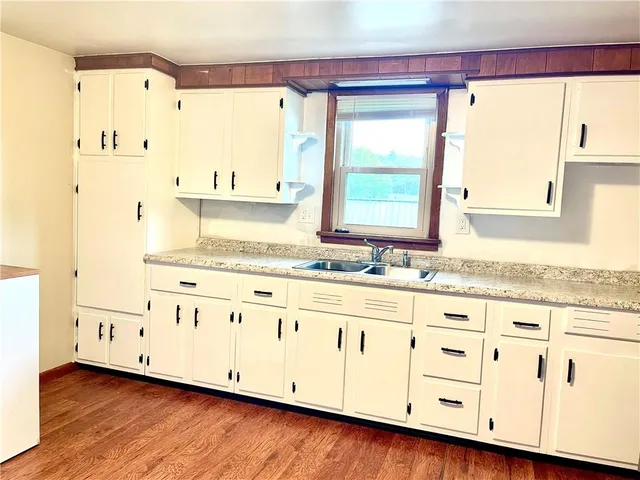 a bathroom with granite countertop a sink and a window
