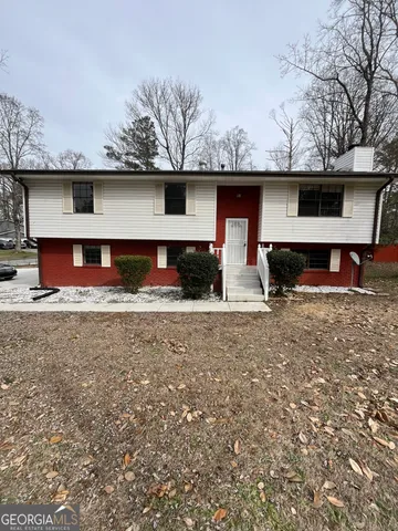 a view of a house with a backyard and a tree