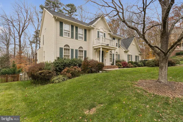a front view of a house with garden and trees