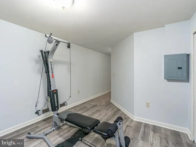 a room with gym equipment and wooden floor