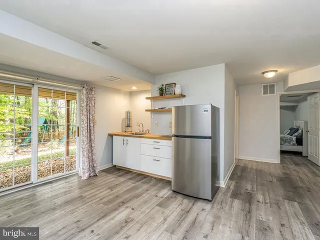 a kitchen with a refrigerator a stove top oven a sink and a large window