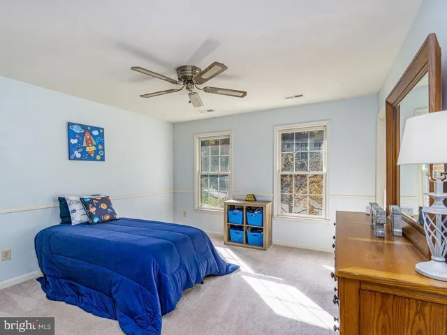 a bedroom with a large bed a chandelier and dresser