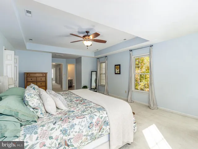 a spacious bedroom with a large bed and a chandelier