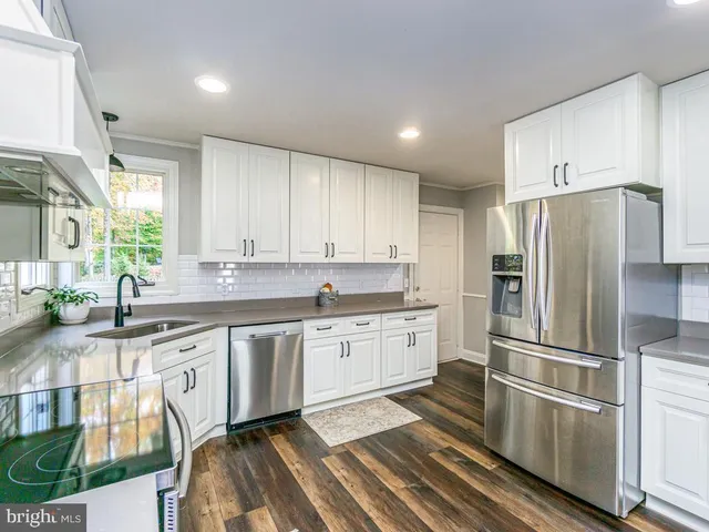 a kitchen with granite countertop stainless steel appliances a sink and cabinets