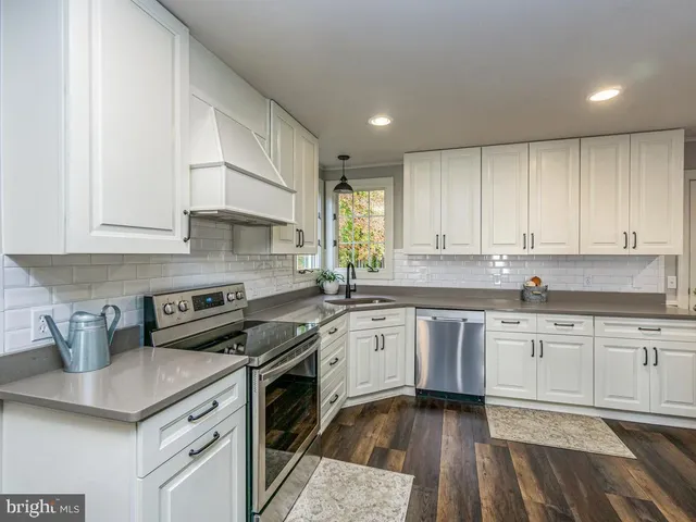 a kitchen with stainless steel appliances granite countertop a sink stove and cabinets
