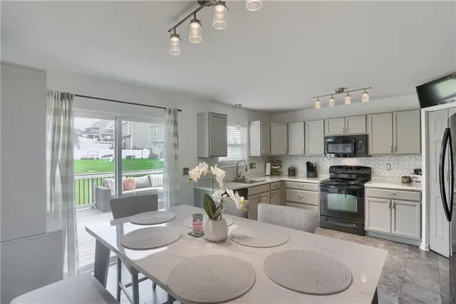 a kitchen with kitchen island granite countertop a sink cabinets and stainless steel appliances