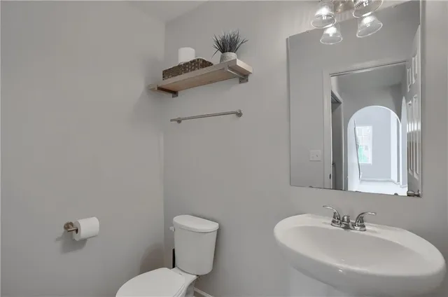 a bathroom with a toilet sink and mirror