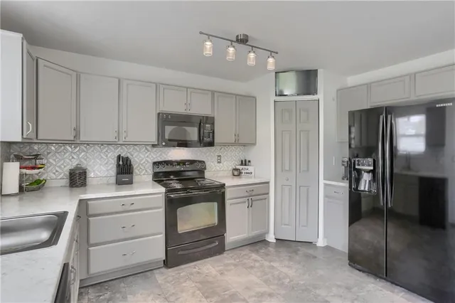 a kitchen with white cabinets and stainless steel appliances