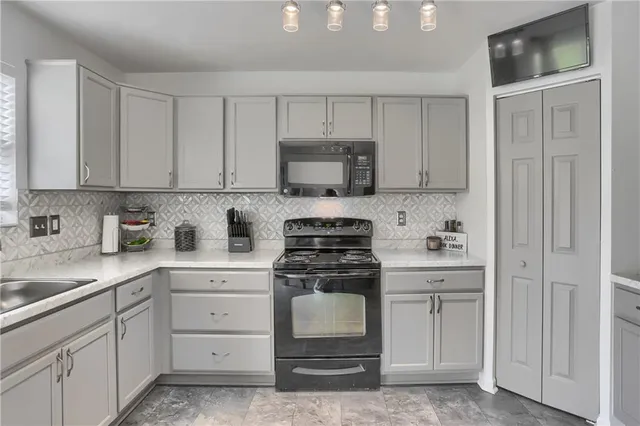 a kitchen with white cabinets and a stove