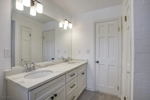 a bathroom with a sink double vanity and a mirror