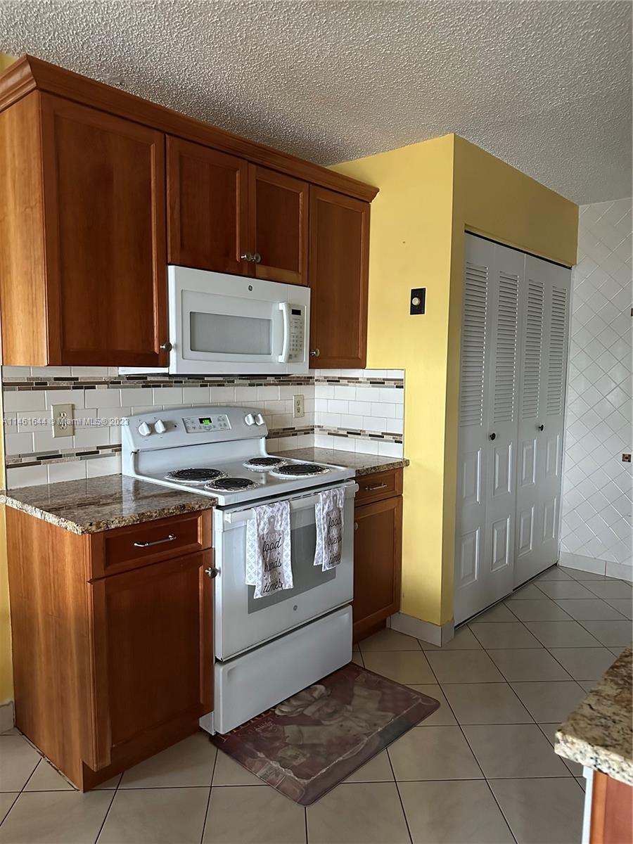 14711 Edna Way Delray Beach, FL 33484 - Photo 1 of 23 a kitchen with stainless steel appliances granite countertop a stove a sink and a microwave