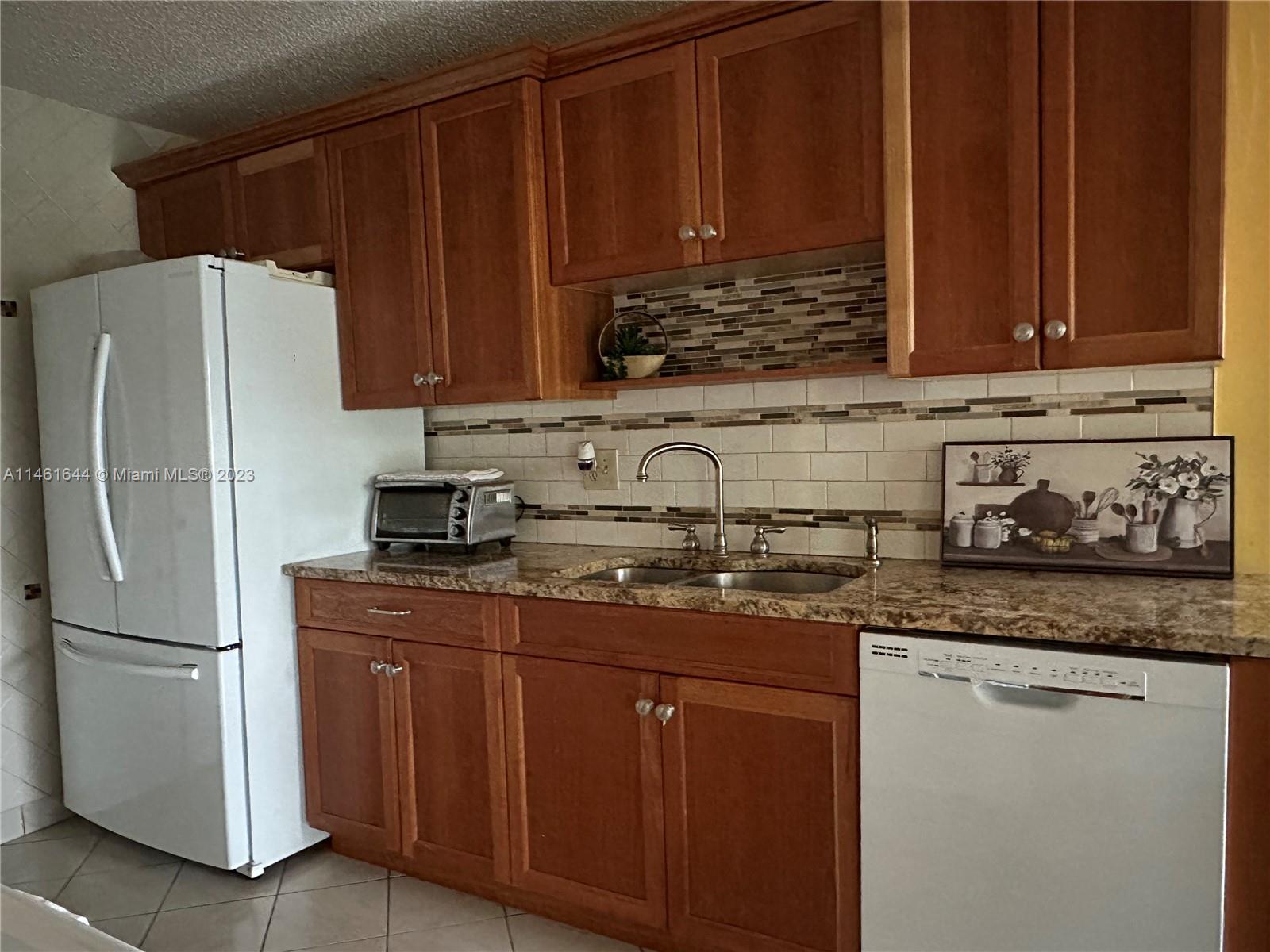 14711 Edna Way Delray Beach, FL 33484 - Photo 2 of 23 a kitchen with stainless steel appliances granite countertop a refrigerator sink and cabinets
