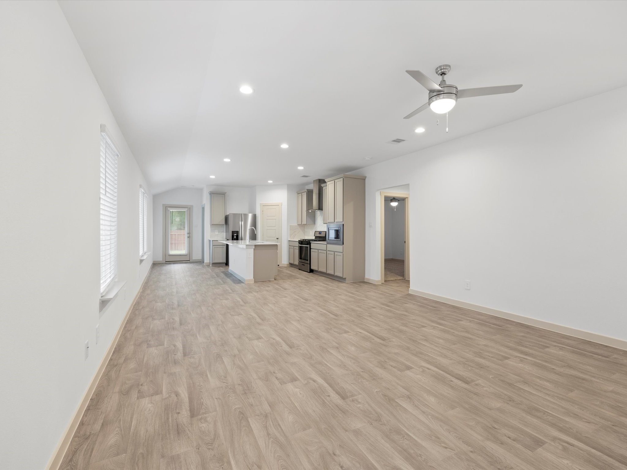 12733 Ermine Street Houston, TX 77047 - Photo 3 of 15 an empty room with wooden floor sink and windows
