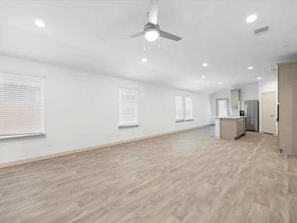 a view of an empty room with a kitchen