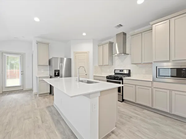 a kitchen with white cabinets and appliances