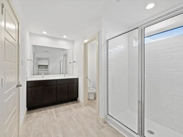 a bathroom with a glass door shower a sink and mirror
