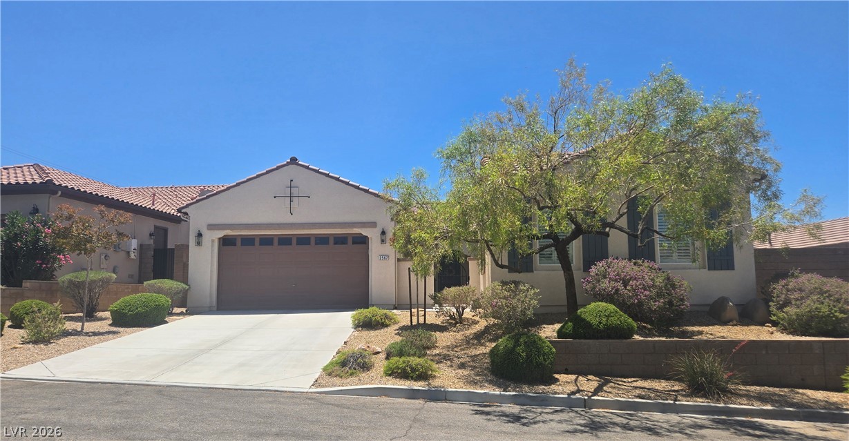 2567 Dirleton Place Henderson, NV 89044 - Photo 3 of 67 A well-maintained stucco home offers a two-car garage and manicured desert landscaping.
