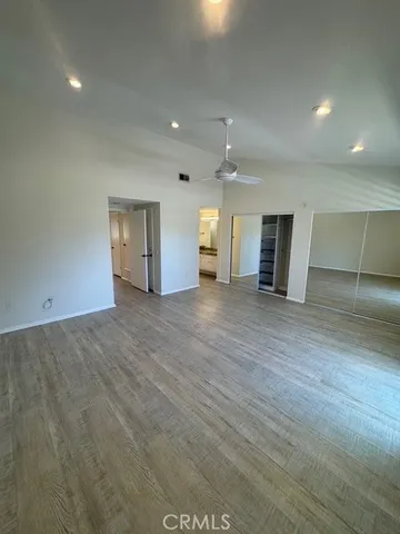 an empty room with wooden floor and natural light