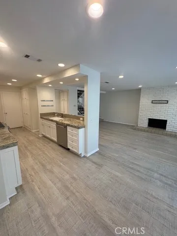 a view of kitchen with kitchen island granite countertop a stove top oven a sink and a dishwasher