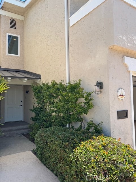 4455 West Coast Highway, Unit 23 Newport Beach, CA 92663 - Photo 21 of 30 a front view of a house with a garden