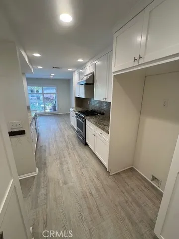 a large kitchen with a lot of counter space and wooden floor