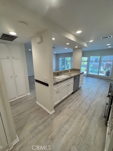 4455 West Coast Highway, Unit 23 Newport Beach, CA 92663 - Photo 24 of 30 a large kitchen with a lot of counter space and wooden floor