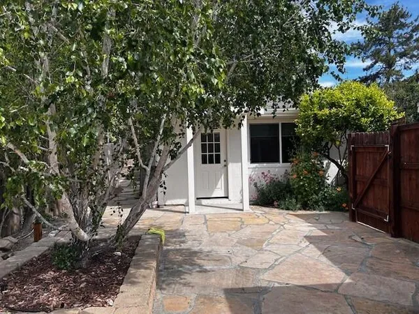 a front view of a house with a yard and potted plants