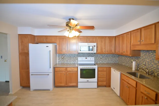 a kitchen with stainless steel appliances granite countertop a refrigerator a stove a sink and dishwasher