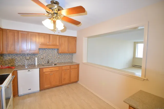 a kitchen with granite countertop white cabinets and stainless steel appliances