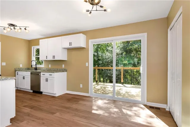 a kitchen with granite countertop a stove a sink dishwasher and a refrigerator