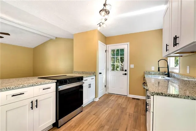 a kitchen that has a sink and a stove in it