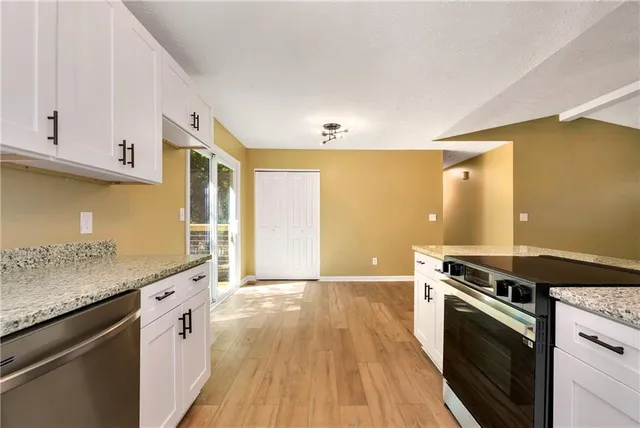 a kitchen with granite countertop a stove and a sink