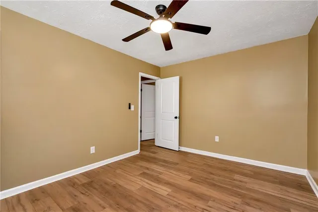an empty room and a ceiling fan with wooden floor