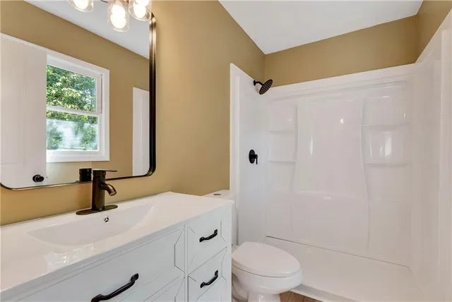 a bathroom with a sink a toilet and shower