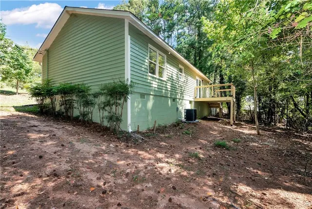 a view of a house with backyard and trees