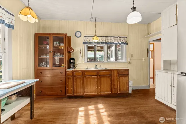 a kitchen with stainless steel appliances a refrigerator and wooden floor