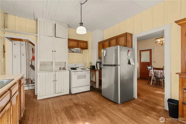 a kitchen with stainless steel appliances granite countertop a refrigerator a stove and a sink with chandelier