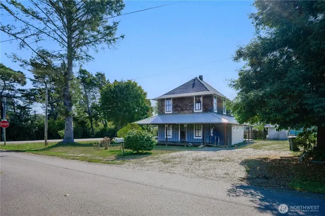 a front view of a house with a yard and trees