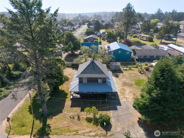 a aerial view of a house with a yard lake and mountain view in back