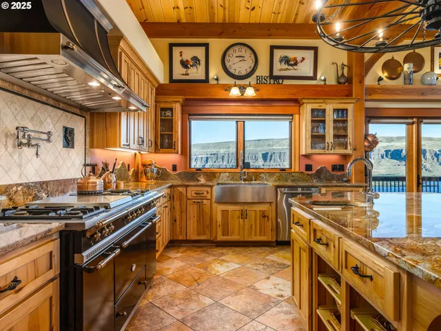 a view of a kitchen with stainless steel appliances granite countertop a stove and a sink
