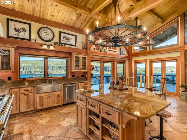 a large kitchen with stainless steel appliances granite countertop a stove and a large window