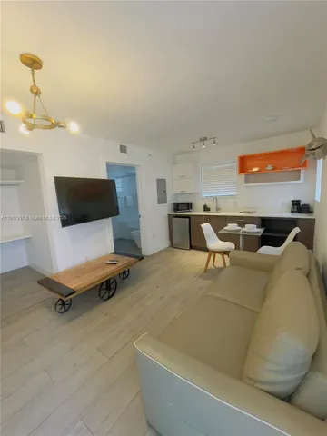 a living room with furniture pool table and a flat screen tv