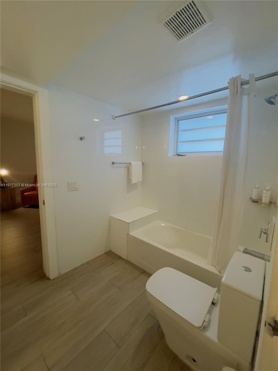 7600 Harding Avenue, Unit 705 Miami Beach, FL 33141 - Photo 5 of 10 a bathroom with a sink a toilet and bathtub