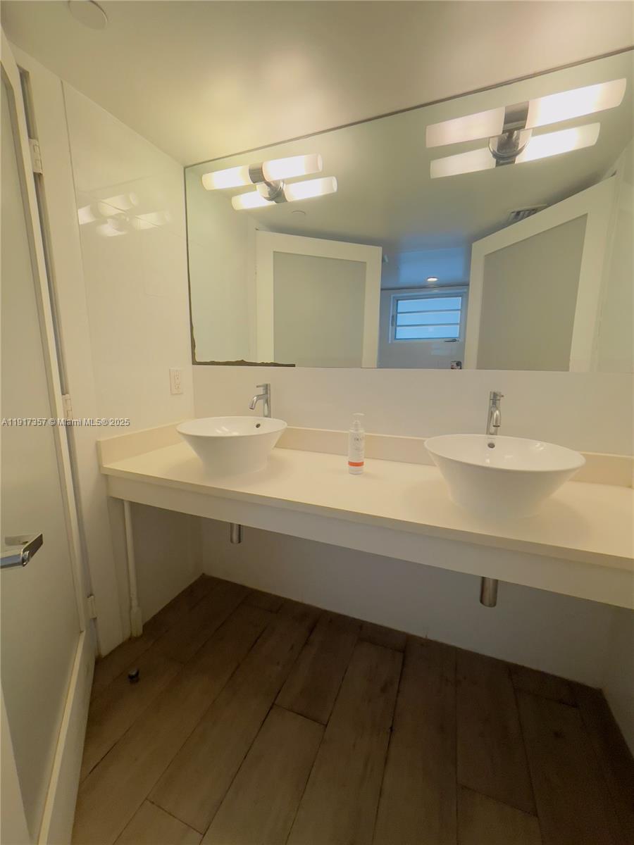 7600 Harding Avenue, Unit 705 Miami Beach, FL 33141 - Photo 8 of 10 a bathroom with a sink and a mirror