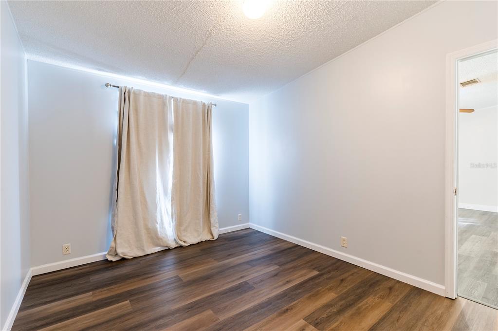 16314 Tiger Trail Spring Hill, FL 34610 - Photo 30 of 43 an empty room with wooden floor and windows