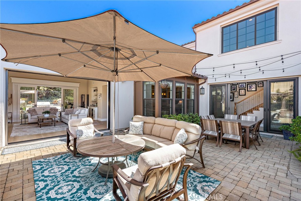 4 Gaucho Road Ladera Ranch, CA 92694 - Photo 27 of 40 a view of a patio with a table and chairs under an umbrella
